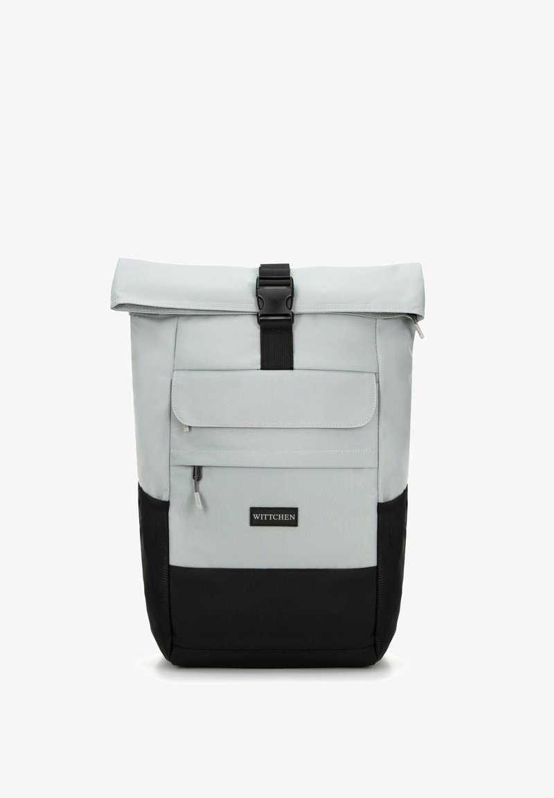 Mochila gris de tipo roll-top fabricada con material duradero y con un fondo negro, presenta un bolsillo frontal con cremallera y un cierre de hebilla. Etiqueta de la marca visible.