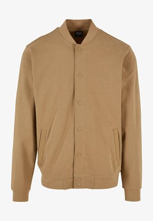 Giacca bomber tan realizzata in tessuto liscio, con colletto arrotondato, chiusura a bottone a pressione e tasche laterali. Maniche lunghe con polsini a costine.