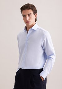 Lichtblauw overhemd met knopen, een gestructureerde kraag, lange mouwen en witte knopen, gemaakt van een gestructureerde stof. Geen patronen of accenten.