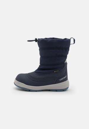 Botte d'hiver bleu marine pour enfant avec fermeture à cordon, étiquette Gore-Tex et semelle épaisse en caoutchouc, vue de profil sur fond blanc.
