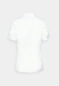 Chemise blanche à manches courtes avec col pointu, manches retroussées et coupe ajustée. Fabriquée en tissu lisse et léger.