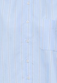 Svetlomodrá košeľa s vertikálnymi bielymi a tenkými modrými pruhmi, bielymi gombíkmi uprostred a malou vreckou na pravej strane.