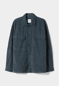 Kostymskjorta i mörk teal, med knapplist fram, spetskrage och två bröstfickor. Texturerat tyg med vertikala ränder.