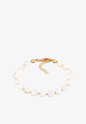 Des perles blanches en forme de cœur avec des accents dorés forment un bracelet. Il est doté d'un fermoir en homard et d'une chaîne d'extension réglable.
