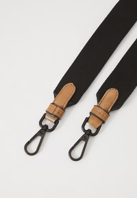 Cinghie elastiche nere con dettagli in pelle marrone; dotate di clip in metallo nero opaco a ciascun estremità per un attacco sicuro.