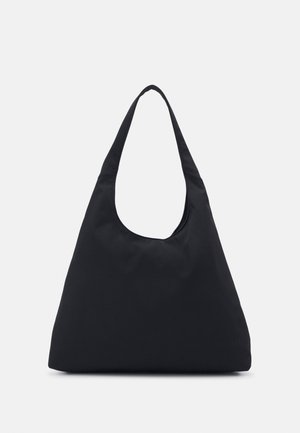 Sac d’épaule noir en forme triangulaire avec une large bandoulière unique et une texture de tissu lisse sur fond blanc.