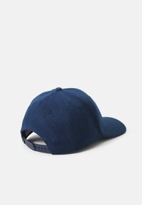 Sötétkék baseballsapka, mely textúrázott anyagból készült, ívelt napszemüveg-kalappal és állítható snapback záródással a hátulján.
