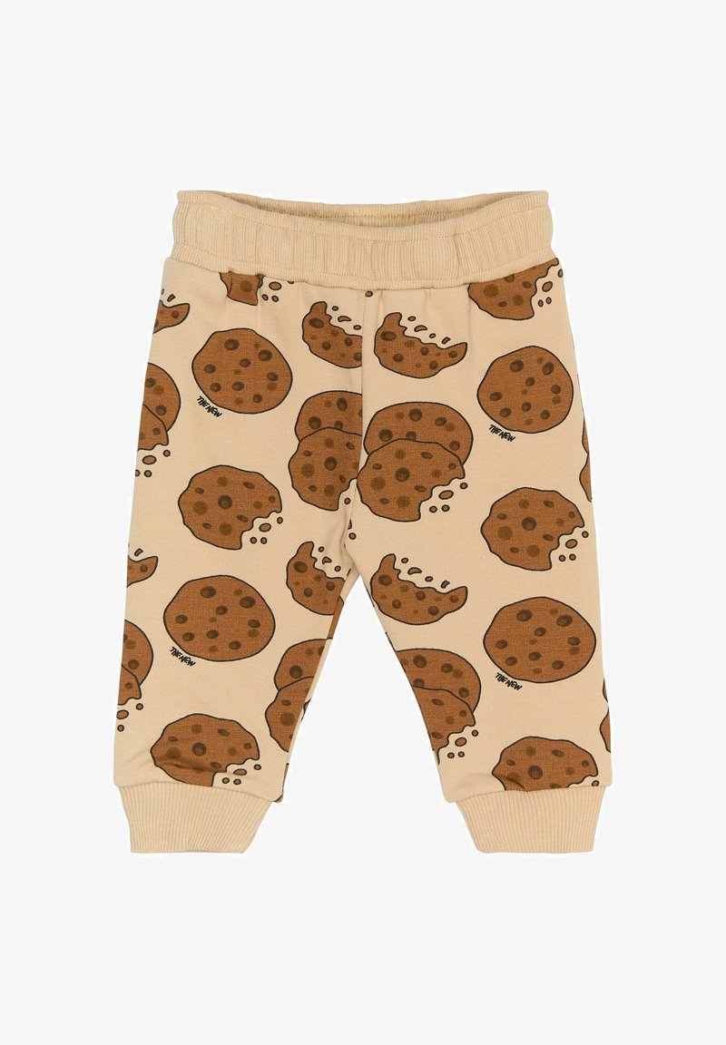 Beige bukser med elastisk talje, der har et kage-mønster i brun. Stoffet virker blødt og har en glat tekstur.