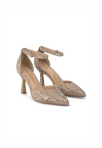 Scarpe beige in suede con tacco alto, punta affusolata, cinturino alla caviglia e decorate con strass in un motivo a onda sulla parte superiore.