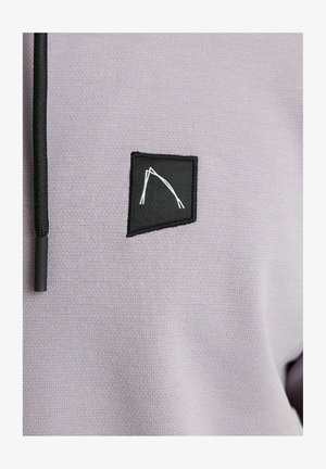 Svetlo purpurna kapuca z značko črno kvadratno z belo abstraktno zasnovo in črnim vrvico okoli vratu.