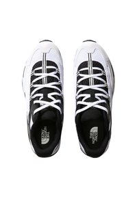 Paire de chaussures de sport blanches et noires à lacets avec le logo The North Face sur les semelles intérieures, vues de dessus sur un fond blanc.