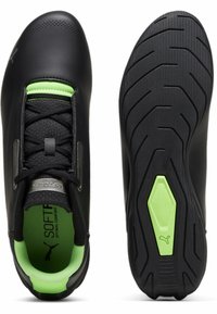 Czarne buty sportowe z zielonymi akcentami, syntetyczna cholewka, teksturowany wzór, oddychająca siateczka wewnętrzna i wzorzysta gumowa podeszwa.