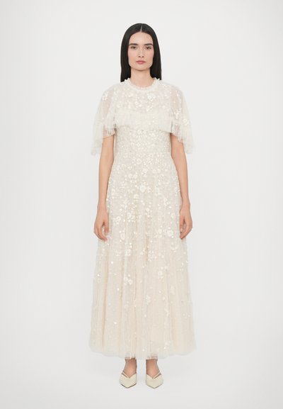 Long, ivory dress with a tiered tulle skirt, embellished with floral appliqués and a soft ruffled short sleeve design; featuring a round neckline.