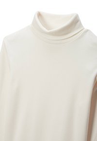 Top à col roulé crème en tissu doux et extensible. Présente un design ajusté et une texture lisse, avec un col roulé et sans motifs visibles.