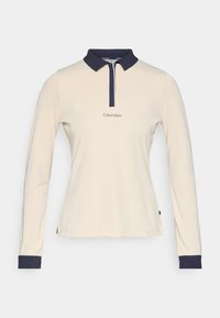 Long-sleeve polo shirt in cream fabric with navy collar and cuffs. Features a central placket and embroidered "Calvin Klein" logo.