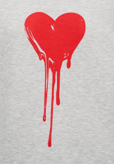 Γκρι μπλουζάκι από ύφασμα με μεγάλο κόκκινο σχέδιο καρδιάς με σταγόνες, που παρουσιάζει ομαλή υφή και έντονη αντίθεση χρωμάτων.