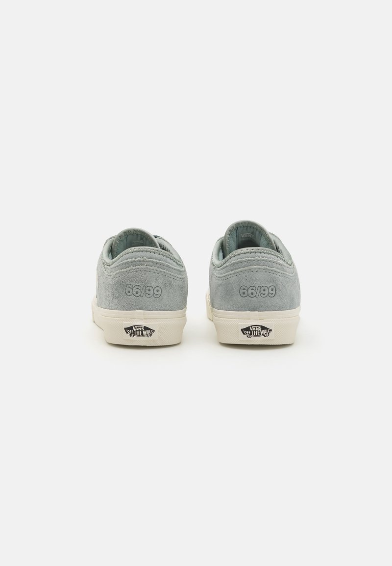 Sneaker in suede azzurro chiaro con suola in gomma bianca, con ricamo "66/99" sul tallone e branding "VANS OFF THE WALL" sulla suola.