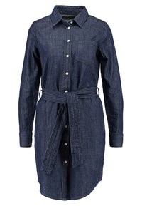 Jeansskjolklänning i mörkblått, med knappar fram, krage, bröstficka och knytmidja för justerbar passform. Långa ärmar.