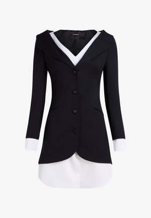 Maßgeschneiderter schwarzer Blazer mit weißem Kragen und Manschetten, strukturiertem Design, sechs Vorderknöpfen und einem geschwungenen Saum für zusätzliches visuelles Interesse.