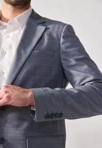 Grau karierter Sakko mit hellblauen Linien, aus strukturiertem Stoff gefertigt. Verfügt über einen Reverskragen und knöpfbare Ärmel mit vier Knöpfen.