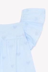 Light blue blouse with short ruffled sleeves, featuring embroidered heart patterns throughout and a gathered waist detail.