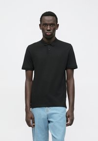Schwarzes Poloshirt mit kurzen Ärmeln, knöpfbarem Kragen, weichem Baumwollmaterial, mit einem kleinen Logo auf der Brust und geradem Saum.