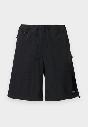 Juodi kelnaitės iki kelių su elastiniu juosmeniu, šoniniais kišenėmis, metaliniu žiedu kairėje pusėje ir mažu logotipu apatiniame dešiniajame krašte.