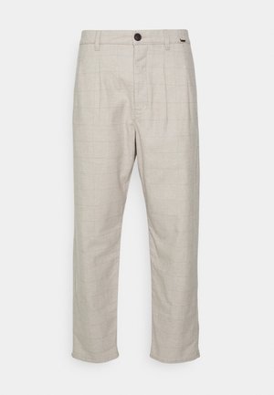 Pantalon beige slim fit avec un motif à carreaux subtil, bouton sur le devant, fermeture éclair et passants pour ceinture.