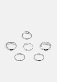 Zestaw sześciu srebrnych pierścionków o różnych wzorach: gładkie obrączki, z akcentami o fakturze oraz z pierścionkiem koralikowym. Wykonane z polerowanego metalu.