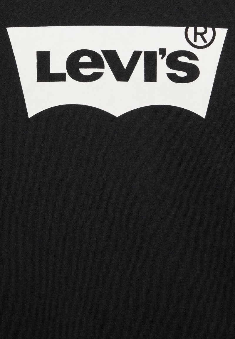 T-shirt in cotone nero con logo Levi's bianco dal design curvo, ben visibile nella parte superiore centrale.