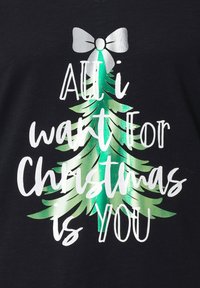 Maglietta nera con grafica di albero di Natale verde con dettagli metallici e testo bianco che recita "Tutto ciò che voglio per Natale sei tu."