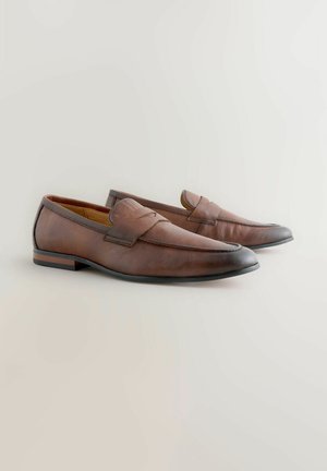 Brown leather loafers with a textured finish, a slightly pointed toe, and a low heel. Features a stitched band across the upper.