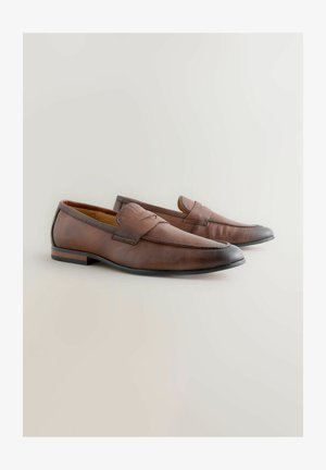 Loafers din piele brown cu un finition texturat, un vârf ușor ascuțit și un toc jos. Prezintă o bandă cusută pe partea superioară.
