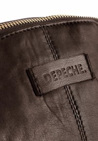 Brūna ādas soma ar teksturētu virsmu, zelta rāvējslēdzēju un gravētu logotipa birku. Redzama šūšana gar malām.