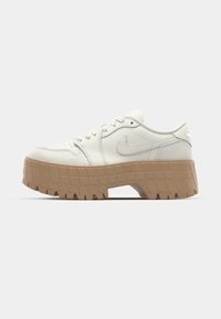 Hvide lædersneakers med beige struktureret platformssål, rund tå, snørebåndsdesign og subtil branding på hælen.