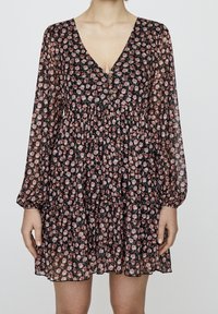 Robe fleurie noire en tissu léger, avec un col en V, des manches longues et une jupe à volants ornée de motifs de roses roses et rouges.