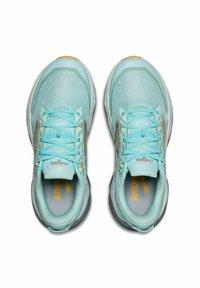 Scarpe sportive azzurre chiare con una tomaia in rete traspirante, accenti gialli a contrasto e una suola ammortizzata. I lacci sono integrati nel design.