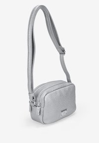 Bolso bandolera de cuero texturizado plateado con cierre de cremallera, forma plana, correa ajustable y detalle de hardware metálico.