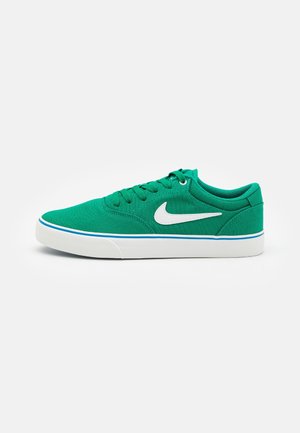 Baskets basses vertes avec logo Nike swoosh blanc, semelle blanche avec bande bleue et lacets verts sur fond blanc uni.