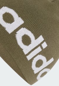Olive green knitted beanie with a textured finish featuring a prominent white logo across the front. Classic, fitted design.