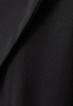 Black fabric with a smooth, matte texture, showing diagonal folds and fine ribbed pattern. The material appears lightweight and flexible.