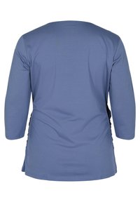 Blå topp med trekvartsärmar och rundad halsringning samt rynkad detalj på sidan. Tillverkad av mjukt, lätt material med en slät textur.