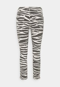 Jeans de estampado de cebra con una mezcla de colores gris y blanco. Presentan un diseño ajustado, piernas rectas y dos bolsillos traseros con detalles de costura.
