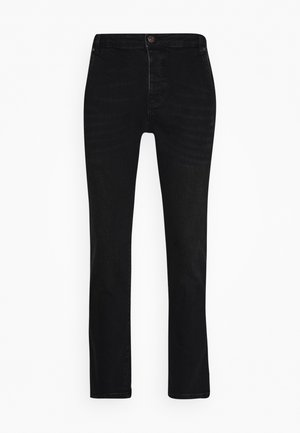 Mustat farkut suoran lahkeensuulla, napilla kiinnitettävä malli ja kontrastiväriset saumat. Tasainen pinta ilman kuvioita tai koristeluja.