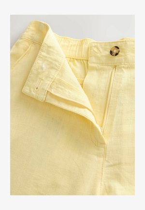 Light yellow linen pants with a flat waistband, a button closure, and a concealed zipper. Features subtle texture and neat stitching.