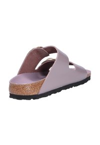 Sandalo viola a slip-on con due cinturini sagomati, suola in sughero, suola in gomma e una finitura liscia. Design leggero adatto per un uso casual.