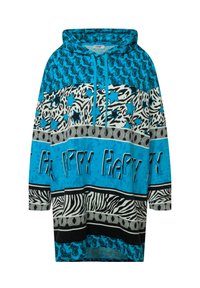 Oversized hoodie in blauw met verschillende patronen: paisley, zebraprint en sterren. De tekst zegt "HAPPY" in vetgedrukte letters.