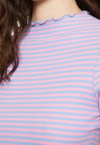 Różowo-niebieski prążkowany top z żebrowanej dzianiny, z dekoltem wykończonym falbanką, dopasowanym krojem i miękką fakturą.