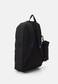 Mochila de tela negra con diseño acolchado, correas dobles para los hombros, bolsillo lateral y acento de logo azul de Nike. Compartimento principal con cremallera para almacenamiento.