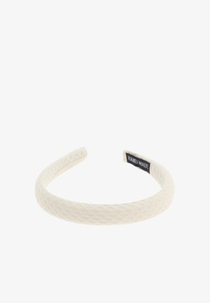 Cinta para la cabeza blanca con textura y un patrón de diamantes, con una etiqueta "HECHO A MANO" en un lado. Fabricada con un material suave y flexible.